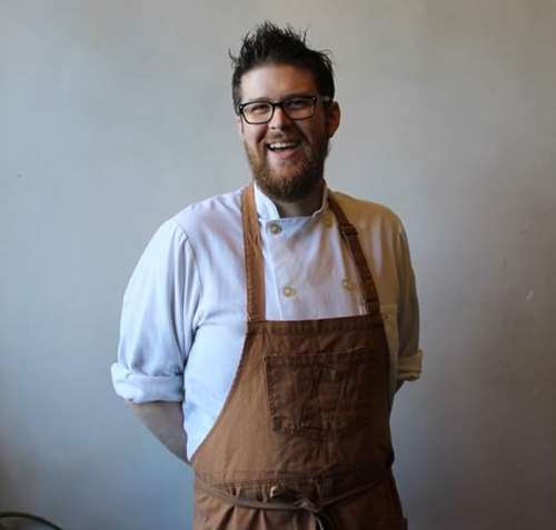 Marc Sheehan posing with his arms behind his back and smiling towards the camera